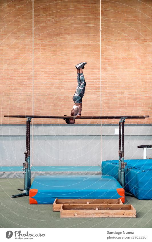 Athlete practicing on parallel bars acrobatic action active activity athlete athletics balance body daylight effort energy equipment exercise fit flexibility