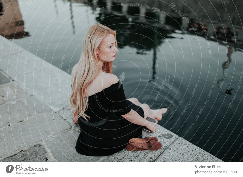 Blonde woman feet Woman Sitting By The Water With Bare Feet A Royalty Free Stock Photo From Photocase