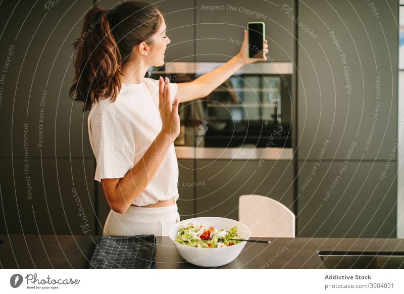 Woman taking selfie in kitchen blogger salad woman food influencer social media smartphone bowl female device fresh vegetable mobile meal young healthy gadget