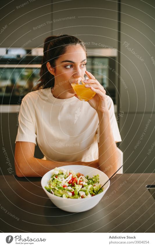 Woman having tasty lunch and drinking juice at home woman orange salad healthy food healthy lifestyle diet female bowl meal dish nutrition vegetable vitamin
