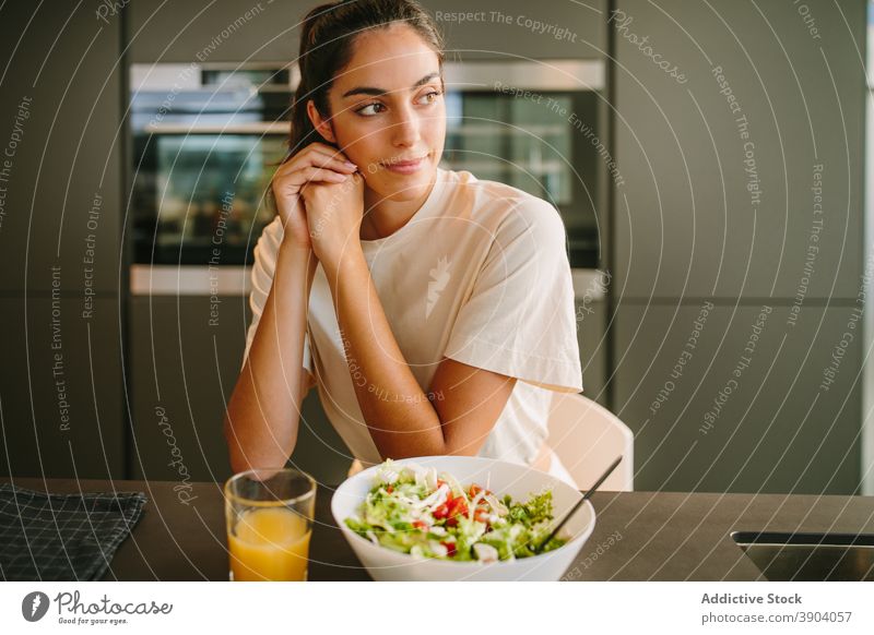Woman sitting at table with juice and salad lunch woman home orange bowl vegetable healthy healthy food female peaceful glass vitamin meal nutrition organic