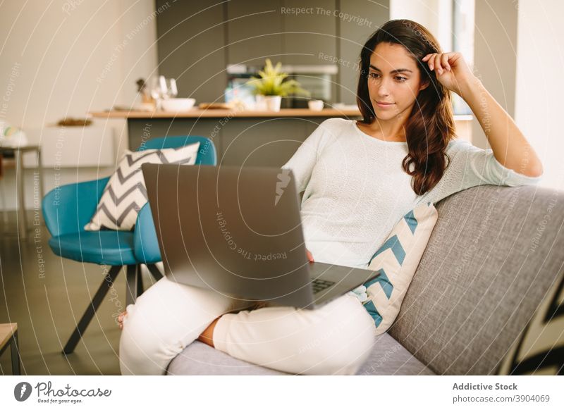 Young woman working on laptop at home using freelance remote casual young online female device gadget browsing internet lifestyle surfing distance connection