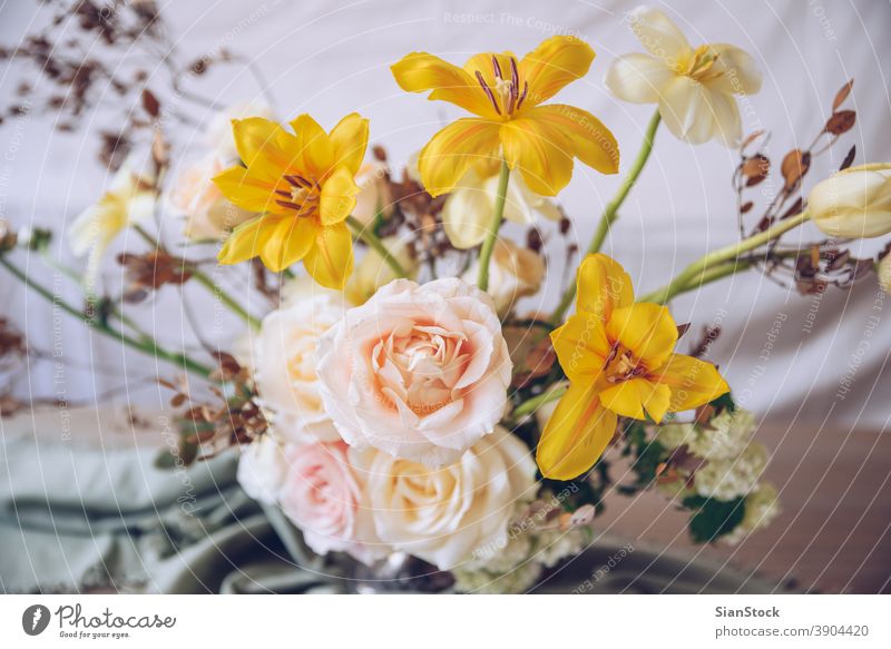 Still life with a beautiful bouquet of flowers table vase wedding decoration white close up yellow background interior arrangement dinner romantic pink rose