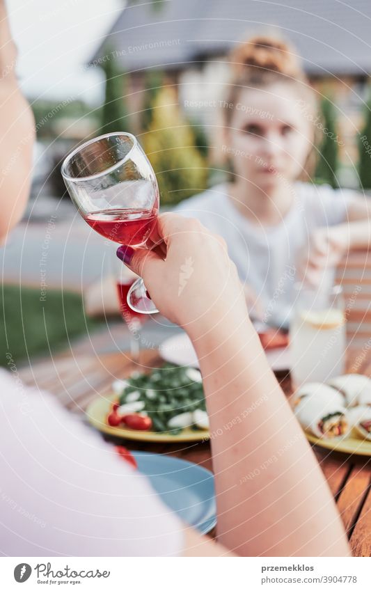 Woman drinking red wine during summer outdoor dinner in a home garden feast having picnic food together woman barbecue table eating gathering people lifestyle