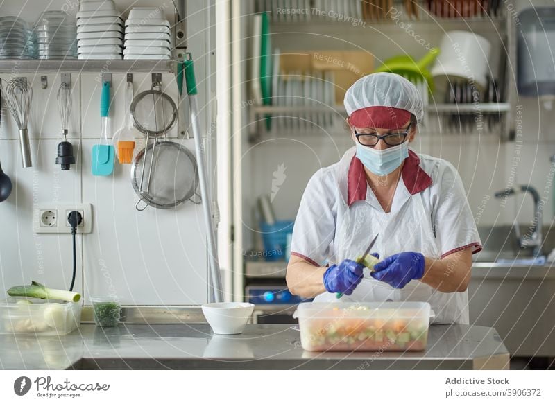 Cook in protective mask and gloves preparing food in kitchen cook coronavirus prepare fruit cut woman work pandemic covid 19 covid19 epidemic female job chef