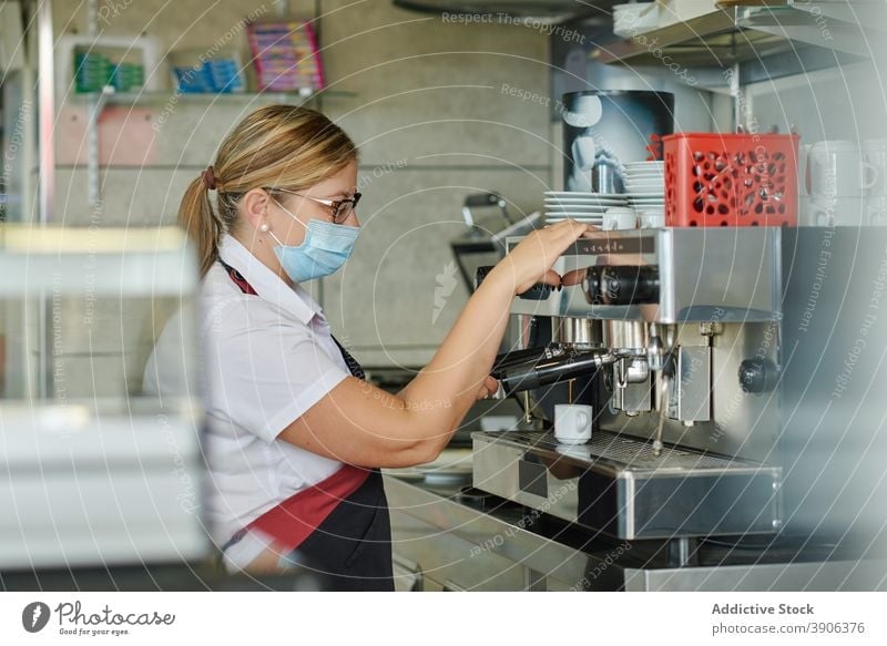 Bartender in medical mask preparing coffee bartender prepare coronavirus covid prevent protect pandemic machine woman barista female espresso cafeteria cup pour