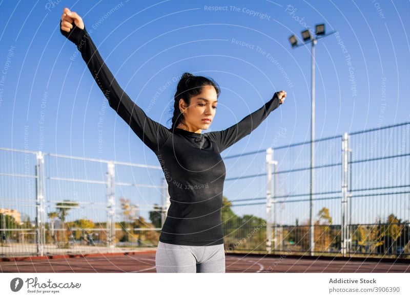 Slender woman warming up arms during calisthenics training warm up stretch sportswoman workout determine sports ground fit female slim slender sportswear