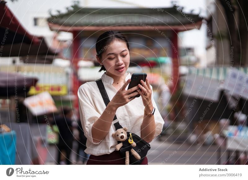 Young woman with smartphone walking on street using browsing traveler check location mobile young asian female ethnic taiwan tainan tourism navigate message