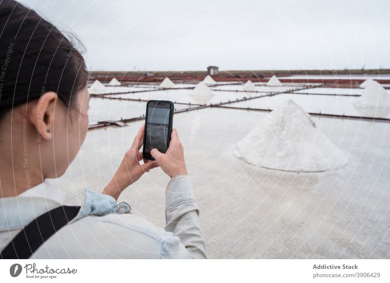 Woman taking photo of salt ponds field woman take photo traveler smartphone nature factory mobile photography visit environment resource crystal farm taiwan