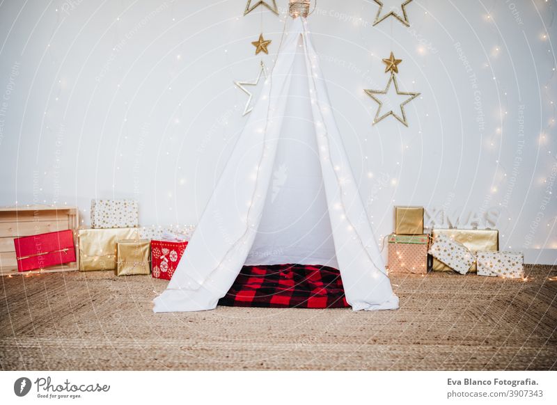 Christmas decoration at home, lights, teepee and presents. Christmas time christmas tent plaid blanket december decorated white tree house indoors holiday