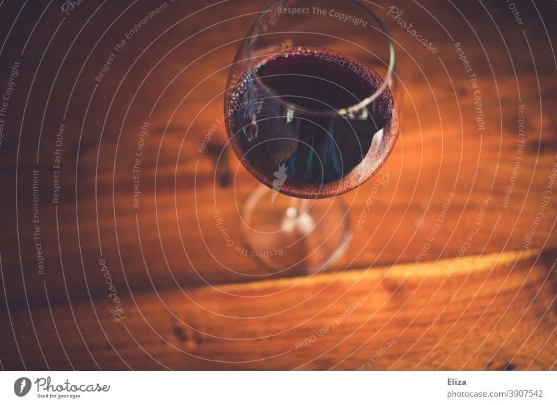 A glass of red wine on a wooden table Red wine Vine Wine glass Wood Redwine glass Alcoholic drinks Wooden table Table plan Bird's-eye view