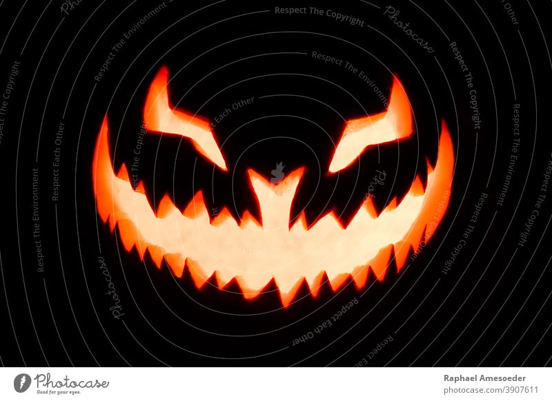 Carved pumpkin glowing in the dark autumn burning candle carved celebration creepy decor decoration evil face fall fear fire flame fruit funny grinning