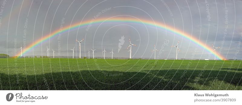 Beautiful rainbow over a wind farm near Friedland Rainbow Pinwheel windmills Field Sky Grain field Renewable energy wind power Energy industry Electricity
