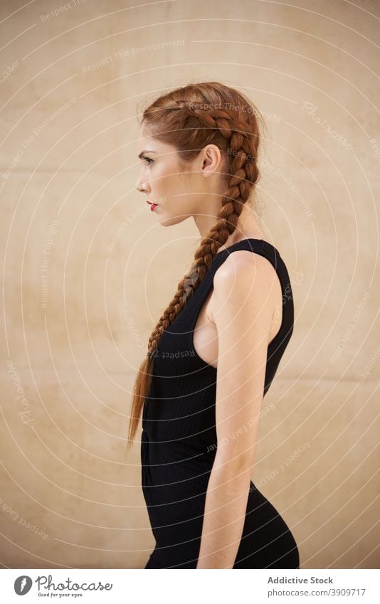 Woman with braids in studio redhead hairstyle woman appearance charming trendy red hair female red lips model personality individuality fashion outfit sit vogue