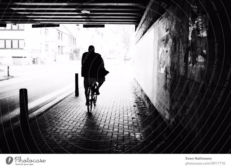 Silhouette on bike rides through tunnel towards the sun people Man Sunlight Tunnel Happy Human being street street photography urban Related To go for a walk