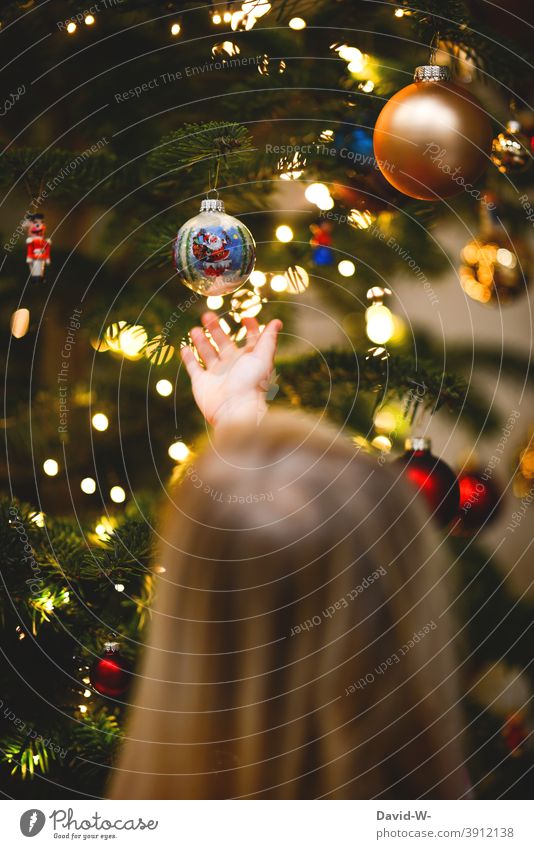 Child looks at the Christmas balls hanging on the Christmas tree Christmas & Advent baubles Anticipation Enthusiasm Tradition Childhood memory fir scent