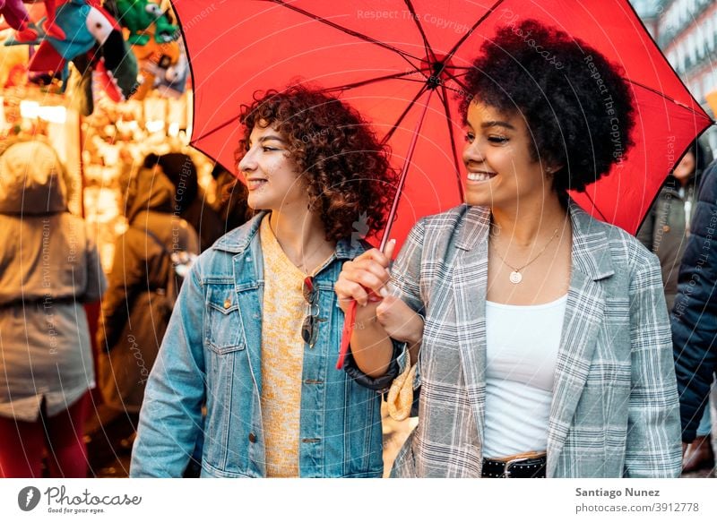 Happy Friends in Rainy Day umbrella rainy day friends afro girl black woman caucasian city life smiling front view portrait women looking street multi-ethnic