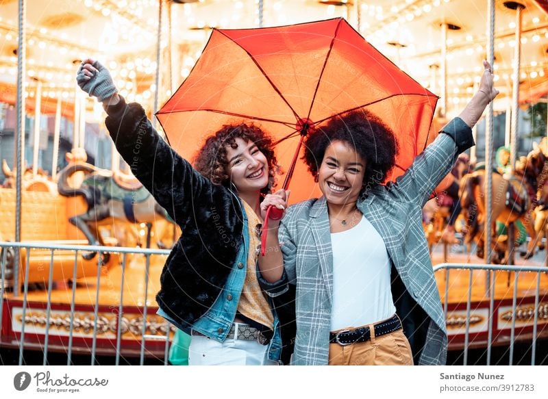 Cheerful Friends in Rainy Day umbrella rainy day friends afro girl black woman caucasian city life smiling front view portrait women looking at camera carousel
