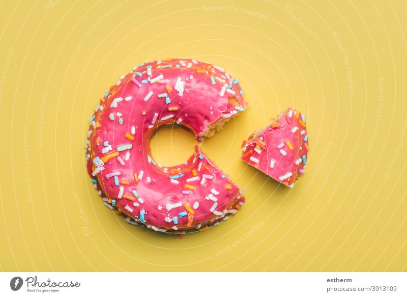 pink donut with icing on yellow background nutrition fast baked pastry item glazed donuts cookie flavor temptation candy sweet food multi colored closeup