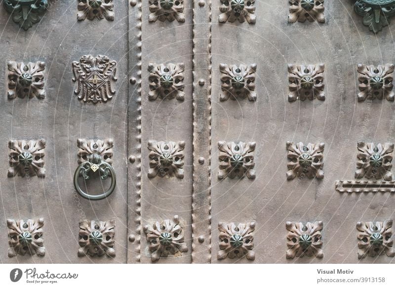 Close-up of an old iron door with decorative studs front architecture detail abstract close-up aged urban ornamental background knocker metallic