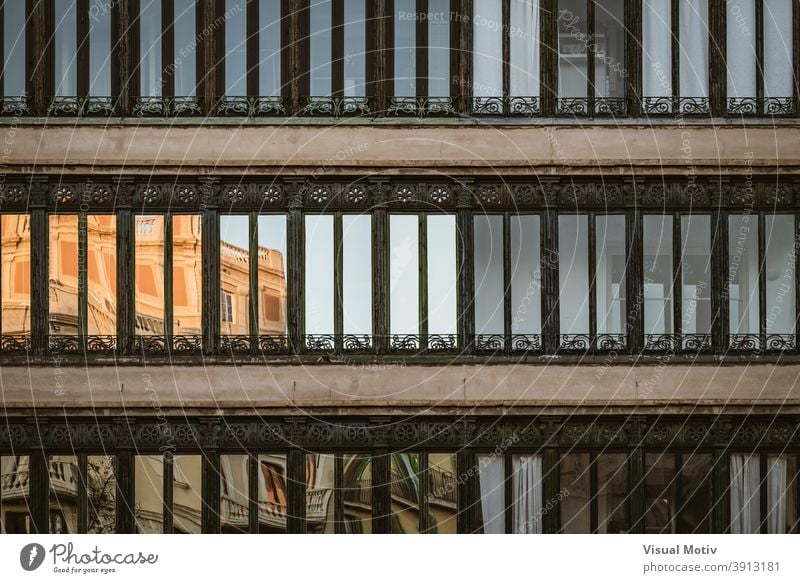 Front view of ornamental windows of a residential building facade architecture exterior structure construction urban metropolitan edifice abstract reflection