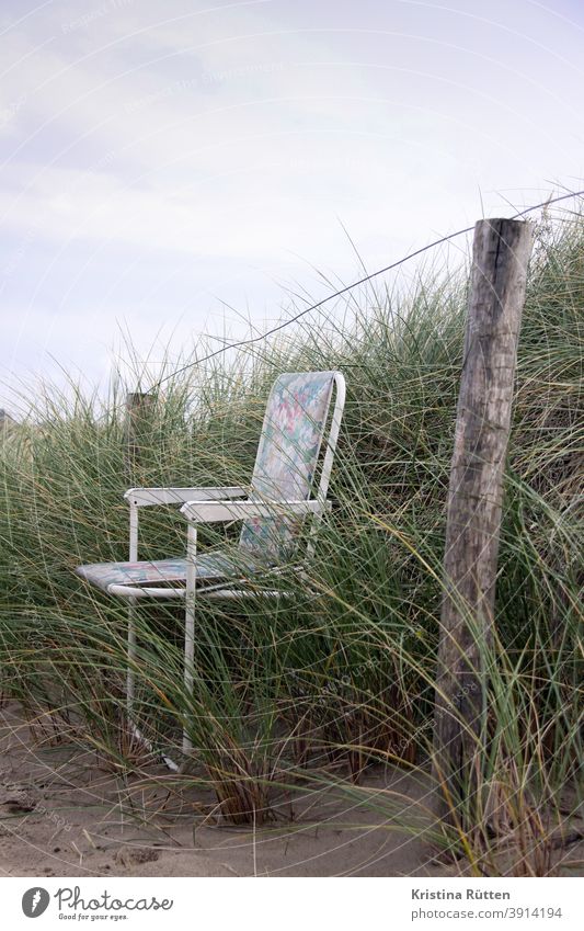 folding chair in dune grass Camping chair Folding chair Garden chair Chair Fence turned off Forget forsake sb./sth. out dunes Marram grass Grass Sand Nature