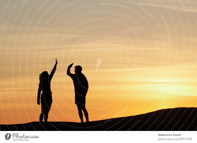 Athletes giving high five to each other in mountains gesture athlete support together sportspeople sunset friend training sportsman sportswoman friendly