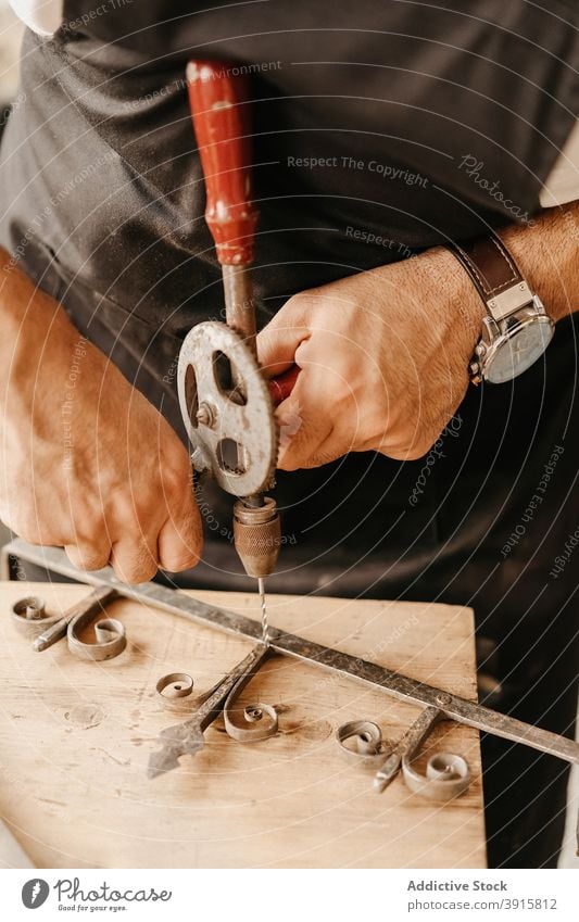 Carpenter drilling wooden detail at workbench carpenter tool old vintage woodwork create instrument artisan professional hand workshop craft workplace