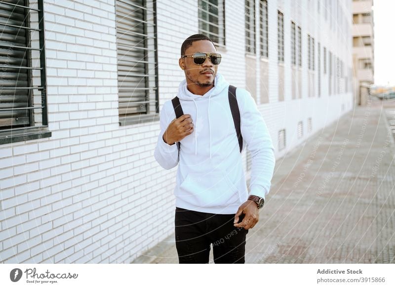 Stylish black man walking along street on sunny day style casual city determine trendy outfit male ethnic african american urban modern confident stroll