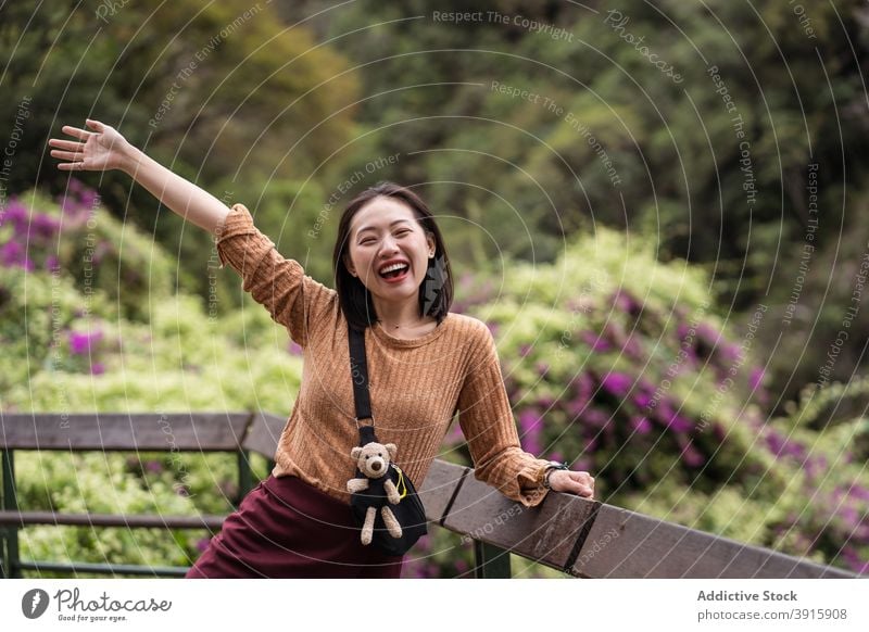 Delighted ethnic traveling woman in green garden excited vacation summer cheerful rejoice park nature female asian hualien city taiwan wooden terrace tourist
