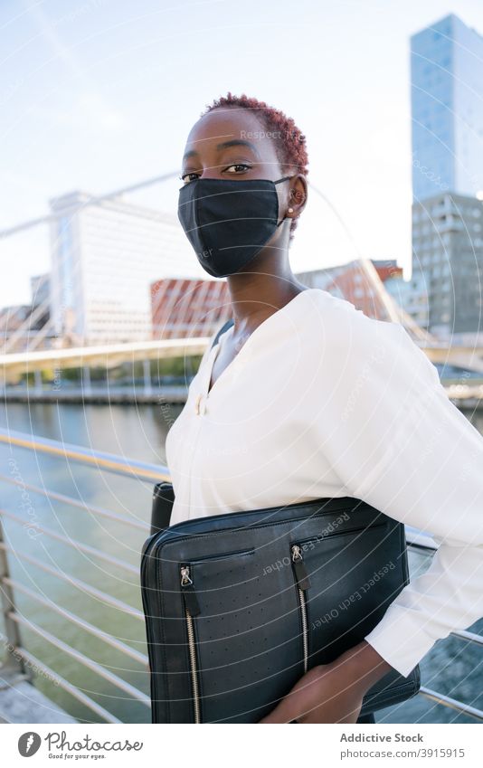 Black businesswoman in protective mask on city street urban confident style modern coronavirus pandemic young black african american ethnic female contemporary