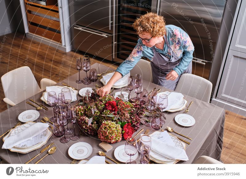 Woman setting table with flowers at home table setting woman festive event housewife floral female decor bloom delicate occasion bouquet prepare celebrate