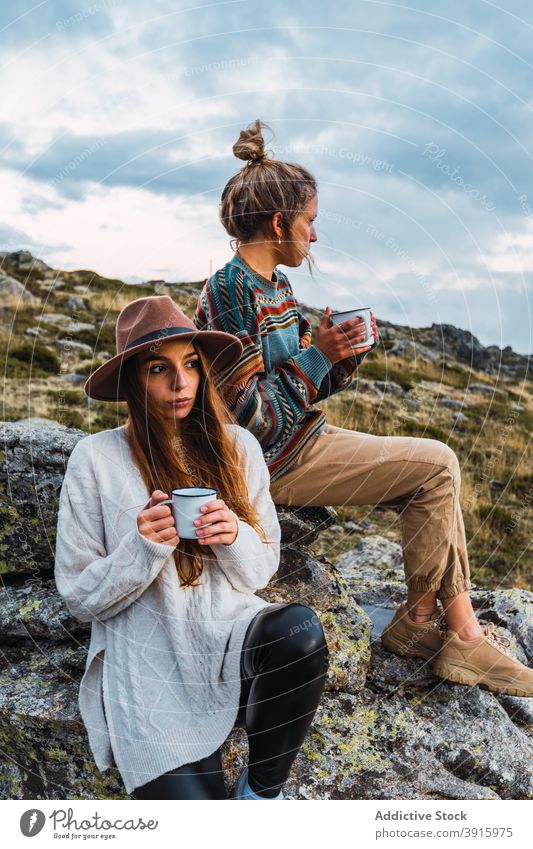 Women with hot beverage in cups in mountains traveler women hot drink highland relax carefree female landscape holiday trip adventure nature tourism friend