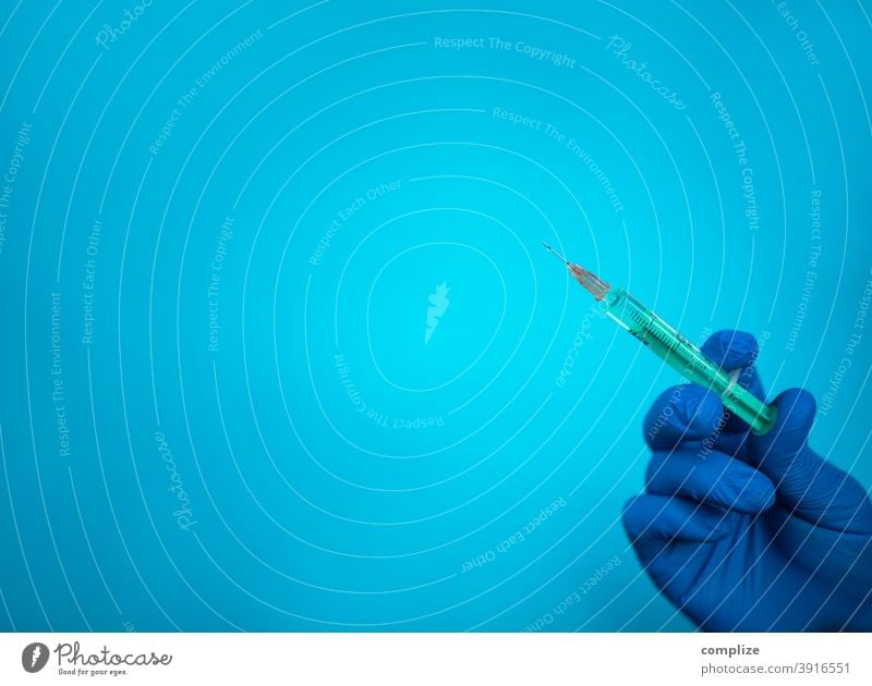 Injection syringe and blue glove against blue background vaccination study vaccination centre Hand Cannula Sterile Table Injectables injection syringe