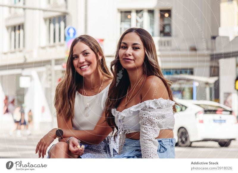 Happy young girlfriends resting on city street together urban meeting happy cheerful positive best friend women alike relationship lifestyle content enjoy