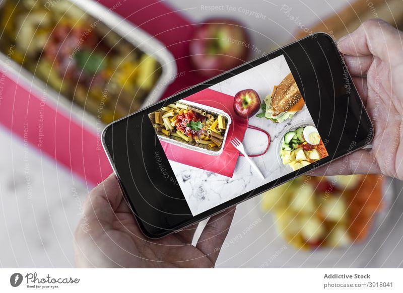 Person taking photo of takeaway food food photography smartphone lunch box take photo pasta salad sandwich apple various delicious healthy meal dish mobile