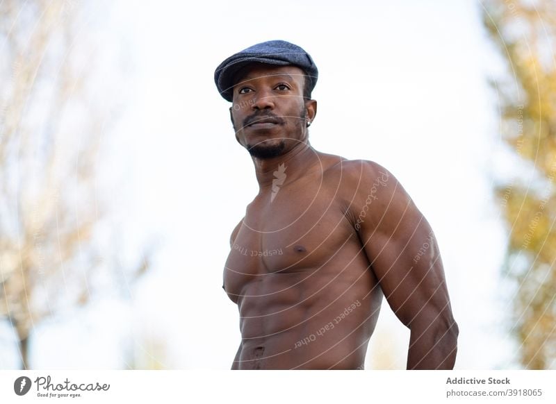 Serious black man with naked torso in park style confident muscular shirtless strong masculine personality handsome male ethnic african american body stand