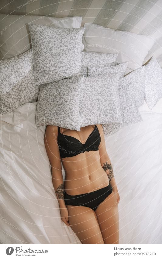 Inked girl sleeping with dozens of pillows in her black lingerie. Sexy curves and tattoos spice it up. The summer body hardly gets better than this.