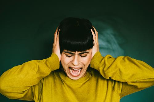 Angry woman covers her ears and screams loudly Anger Woman rabid Scream Distress Sour Frustration Aggression Aggravation Human being Emotions Grouchy Stress