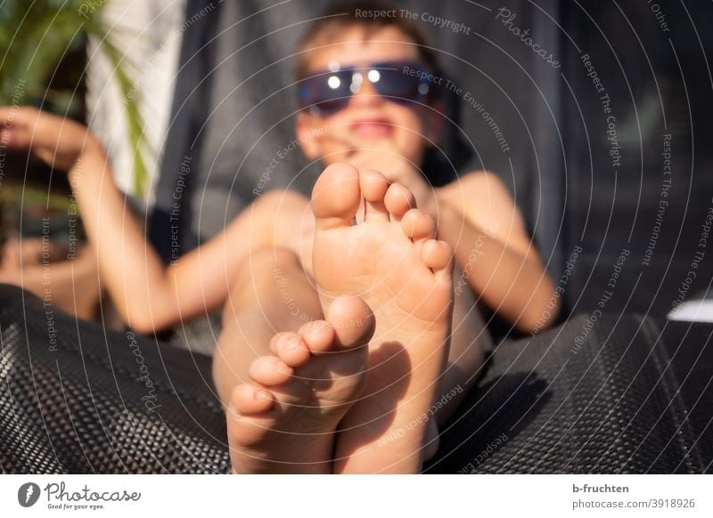 Kid with sunglasses lying on a deck chair Summer Sun feet Legs Toes Child Lie Relaxation holidays Barefoot Vacation & Travel Feet Exterior shot Sunglasses