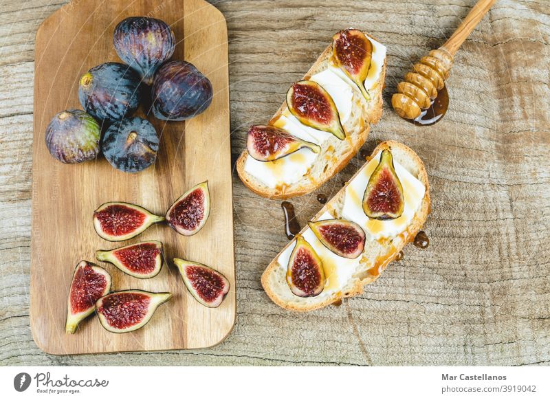 Figs cut on toast with cheese. figs bread breakfast snack ripe fruit whole kitchen table wooden bottom copy space top view purple tasty piece delicious sweet