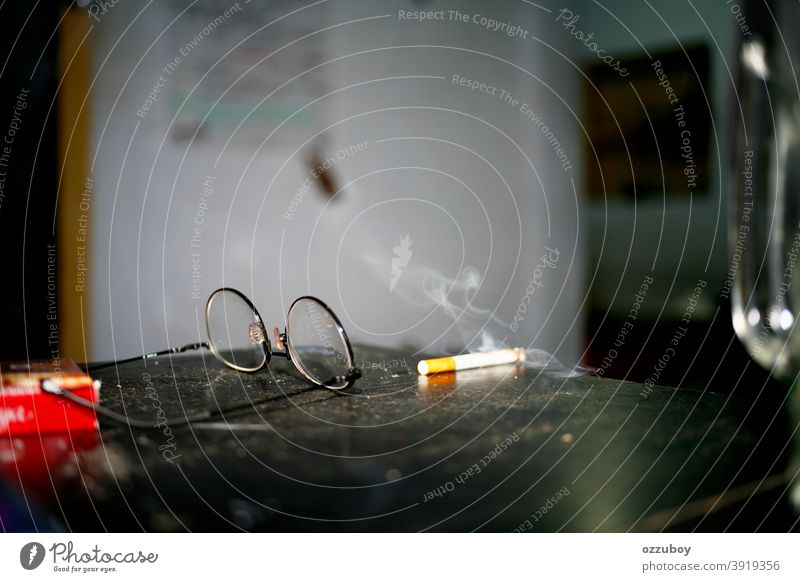 cigarette and eyeglass on the table Cigarette Smoking Addiction Tobacco Tobacco products Nicotine Unhealthy Dependence Harmful to health Cigarette smoke Smoke