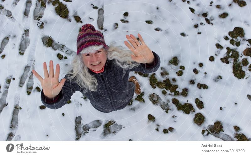 Drone shot of woman in snow waving upwards Woman Winter Snow Wave Laughter Aerial photograph droning UAV view drone Funny fun pleased laughing Senior citizen
