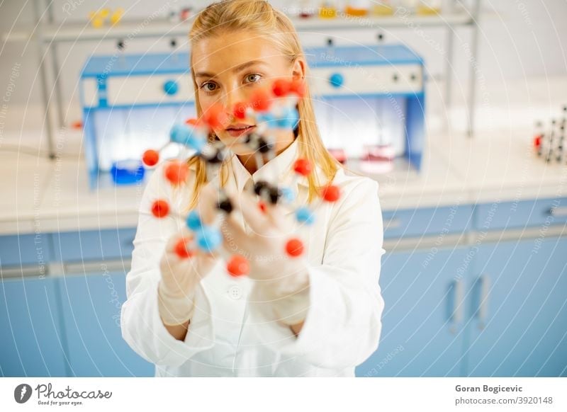 Female chemist hold molecular model in the lab analysis analyzing atom atoms attention biochemistry chemical concept discovery education experiment expertize