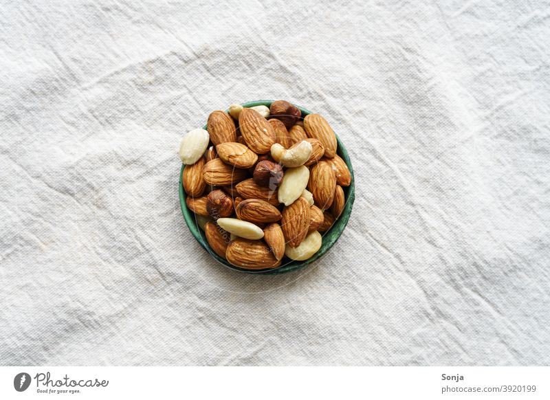 Variation of nuts in a bowl on a beige linen tablecloth. Top view. variation Linen Beige Protein Healthy Delicious Food Fresh Raw Diet naturally Organic