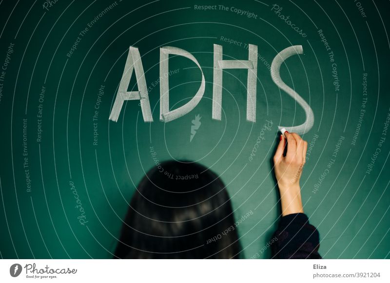 A young woman writes ADHD on a blackboard Disturbance Illness Attention deficit diagnosis Attention deficit syndrome hyperactivity