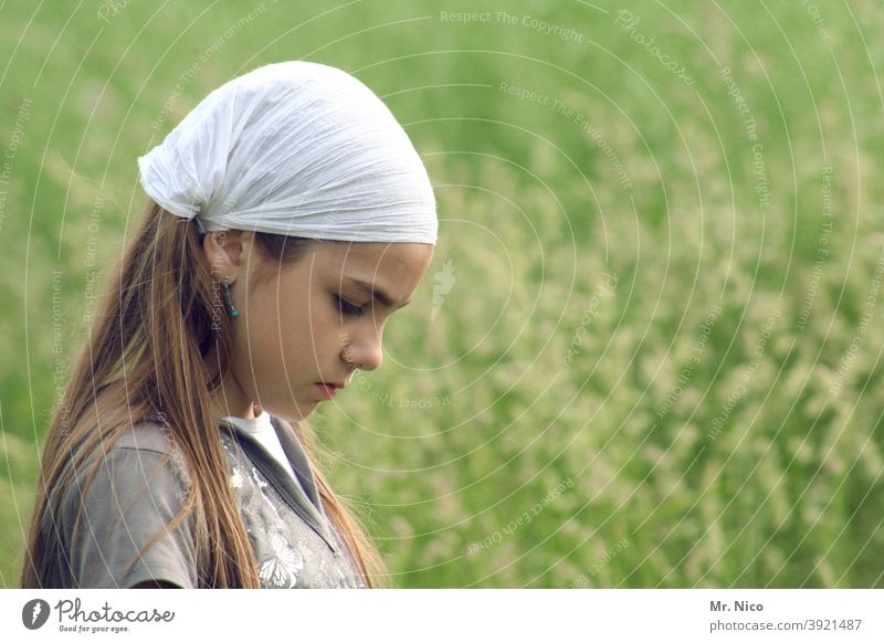 Young girl with headgear looks to the ground - a Royalty Free Stock Photo  from Photocase