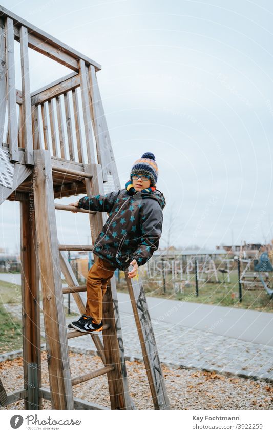 black boy climbs on playground african american boys carefree casual clothing child childhood children climbing cold dominance emotion expression freedom