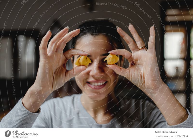 Cheerful woman with tortellini in kitchen cover eyes food cook having fun dumpling cheerful house female young smile home delight meal italian food
