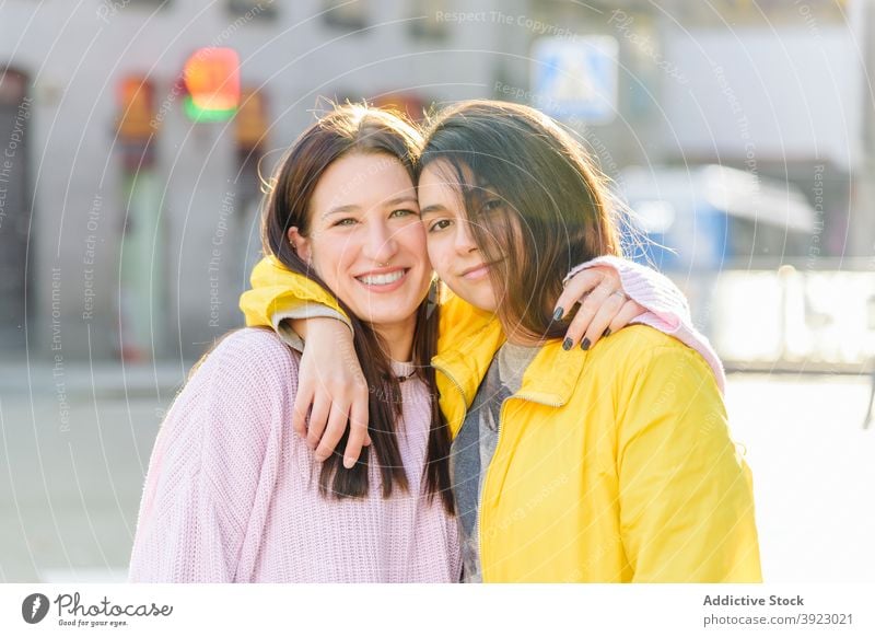 Loving couple of lesbians hugging on street women lgbt same sex gay cheerful cuddle city together relationship tender partner embrace happy affection girlfriend
